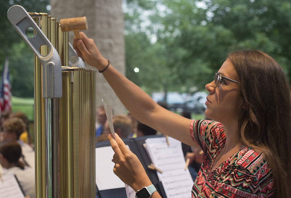 Megan McDevitt, a choir teacher at Charleston Middle School, plays the chimes during the Charleston Community Band concert Thursday at Kiwanis Park.