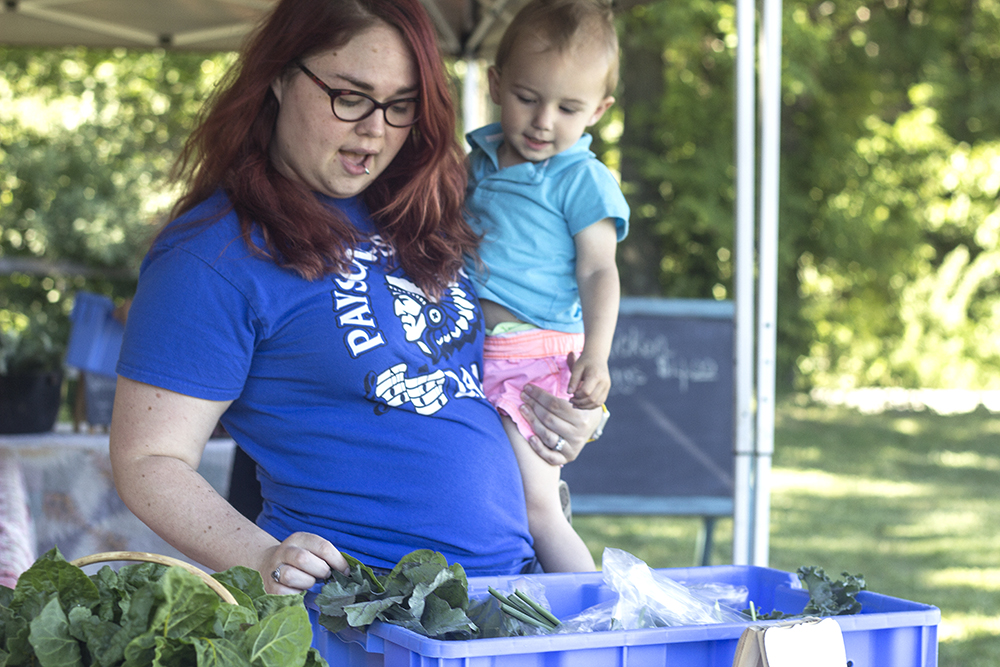 Jennifer Grindstaff, a teacher at John Wood community colleges looks over her produce with her son Hershal.