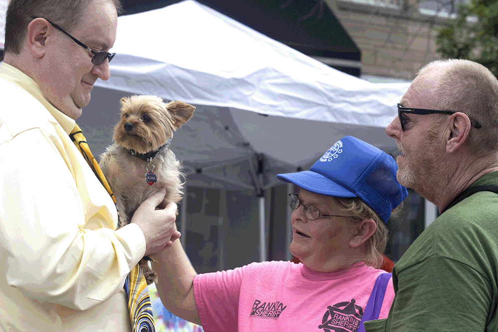 Charleston residents Sharron and Tim Griffin pet Jerald Bennet’s dog Bubba at Musefest on Saturday.