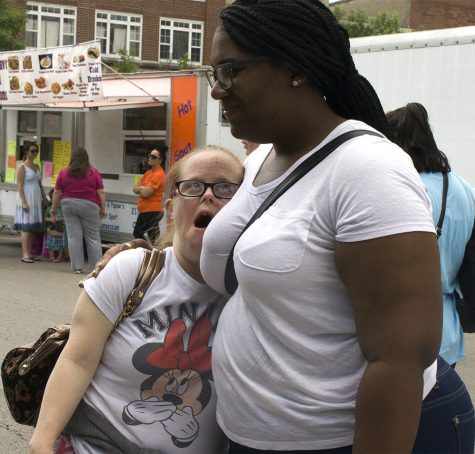 Tinley Park resident Ivory Moore hugs Noreen Canvain while they look at art during Musefest Saturday in the Square. Moore said they took the two and a half hour trip down from the Charleston Transitional Facility’s Tinley Park office. Even though they had only been at the festival for about 20 minutes, Moore said they were enjoying themselves.