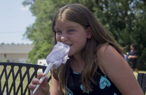 Noraa Cross, a ten-year-old from Greenup, eats her cotton candy Sunday during a carnival hosted by the Arbor Rose Adult Day Care and Memory Care Home. The carnival was an effort to raise money for the Alzheimer's Association.