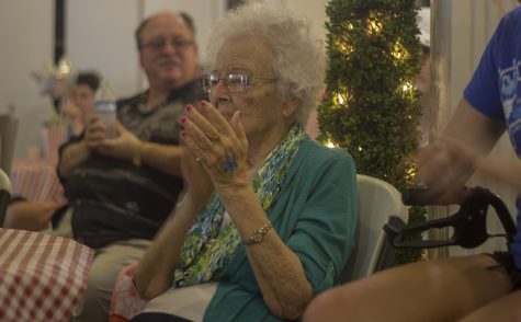 Verna, a resident at Arbor Rose Adult Day Care and Memory Care Home, claps along to a musical performance Sunday afternoon during the home's first summer carnival. The carnival was a way to raise money for the Alzheimer's Association. 