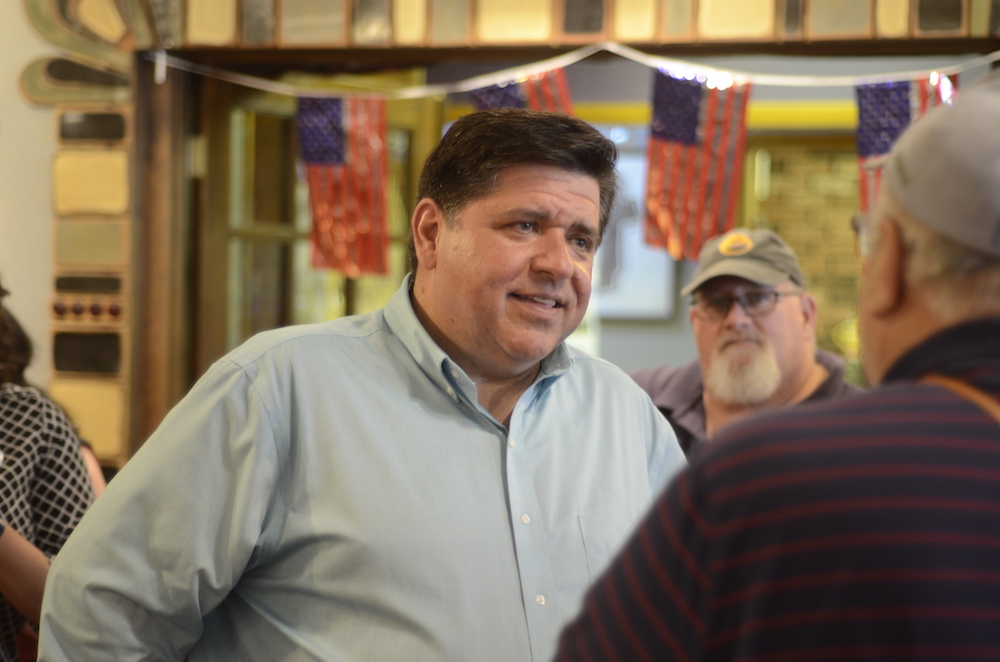 J.B. Pritzker talks with a Charleston resident Wednesday after a meet and greet at the Jackson Avenue Coffee shop.
