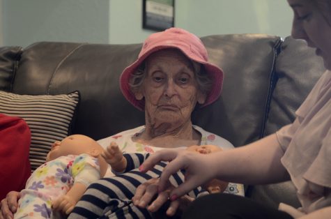 Maxine, a resident at the Arbor Rose Adult Day Care and Memory Care Home of Charleston, tells Erin Byrne, an intern, about her ring as she holds her baby dolls Wednesday afternoon.