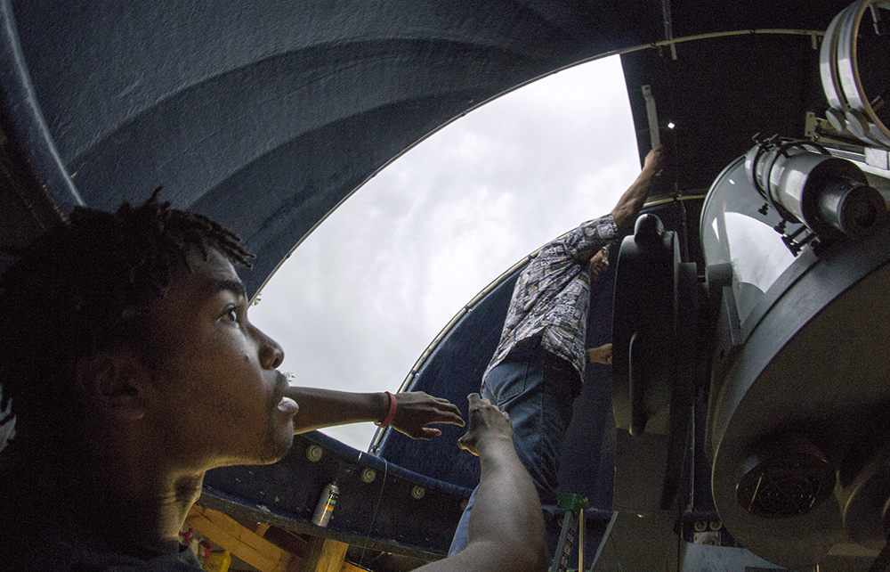 Nathan Barnett-Bishop, a junior engineering major, spots his adviser Douglas Brandt, professor in the physics department, who was struggling to get the hatch of the observatory closed to prevent rain from getting inside and damaging the telescope. “I’m just figuring it out as I go,” Brandt said after explaining that many of the faculty members who have more training in the observatory went farther south for their eclipse viewing.