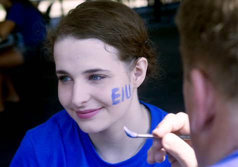 Angelina Loparco, a secondary education student here at Eastern, gets the EIU letters painted on her cheek Saturday in the walkway lounge at the Martin Luther King Jr. University Union. Angelina is showing her school spirit with a smile.