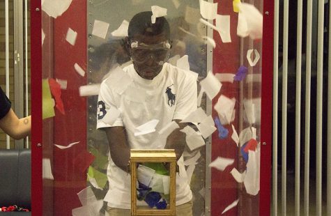 Jalon Emanuel, 13, grabs paper at the cash cube for a chance to win a prize at FUNfest in the Martin Luther King Jr. University Union on Saturday night. Emanuel came to visit his sister for Family Weekend. He won a $5 gift card for Steak ’n Shake.