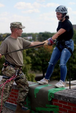 Major Roy Waldhoff,a rappel master, encourages Ruth McMullen, a freshman JROTC student from Richland County High School, who was afraid to rappel off the side of Klehm Hall Friday afternoon during the ROTC rappelling training event. "I felt like I couldn't do it and I was nervous," MCMullen said. "But when everyone was clapping for me, I felt like I could do it." After some coaxing and words of encouragement, McMullen rappelled her way down to the mat below. She said it was her first time doing so and her first time at Eastern. 