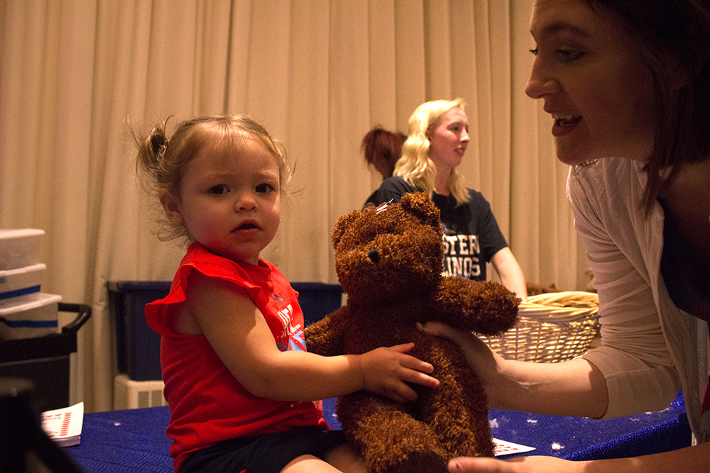 Grace Lee Probus, 2, grabs a bear from her mom Heather Probus at the bear stuffing station which was part of FUNfest at Family Weekend on Saturday night. They traveled from Lovington to visit Heather Probus’ cousin who is an Eastern student.