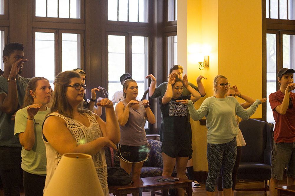 Students warm up for the “EIU Go” event at the Pemberton Great Room. The gestures they are making are related to the four houses from the Harry Potter book and movie series.