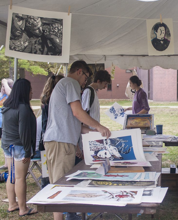 Students browse prints created by student artists at a print sale hosted by a collaboration between the Art Association, the Illinois Art Education Assocation and Blue Room Magazine.
