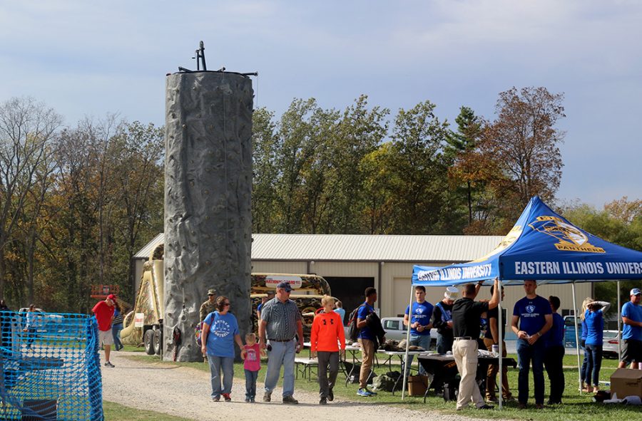 Dozens of families gather at the homecoming tailgate event Saturday afternoon. Many acvtivities are held for people of all ages, including a bouncy house, obstacle course, and a rock wall (as pictured).