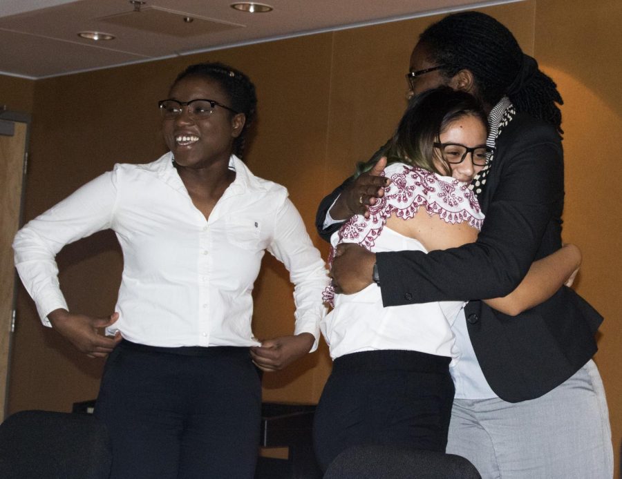 Claude Abdoulaye- Pedila (left) a psychology major, smiles while Catherine Polydore a proffesor of counseling and student development hugs Yesenia Murato a sophmore sociology major after the Immigration Panel at Doudna hall Monday night.