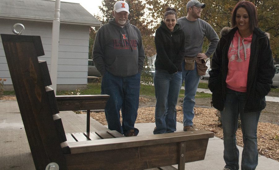 Cassie Buchman | The Daily Eastern News Mattoon resident Aisha Crowe, standing by her daughter and a couple of volunteers from Habitat for Humanity, admires the porch swing made by Eastern’s Construction Club. The porch swing was presented to Crowe on Saturday morning.