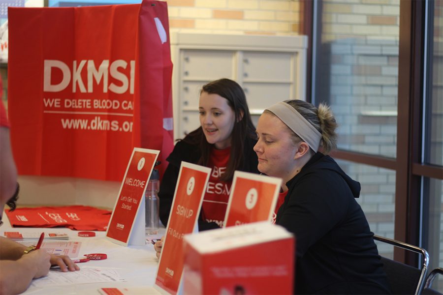 President of Colleges Against Cancer Madison Carlson (back), a junior family consumer sciences major, and vice president Catherine Lestina (front), a junior elementary education major, help students sign up to become stem cell or bone marrow donors.