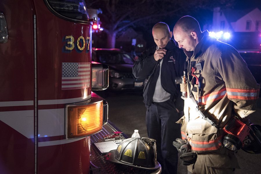 Steve Bennett (left), chief of the Charleston Fire Department, discusses the situation with a firefighter in the parking lot of Douglas Hall Wednesday night after the buildings attic caught on fire.