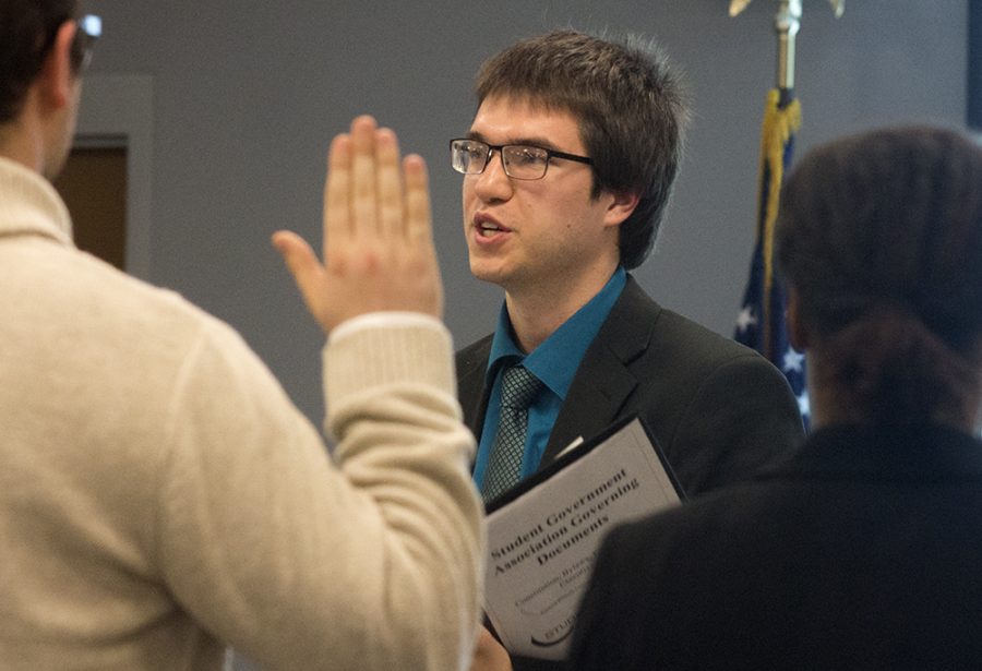 Student Body President Luke Young swears in five new senators during the Student Senate meeting Wednesday night. During the meeting, senators were asked to give their feedback on a comprehensive bike plan that involves creating a bike path through campus.