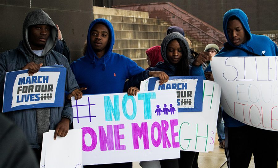 People hold up signs during March For Our Lives Saturday afternoon in the Library Quad. Students, community members and activists alike listened speakers talk about their issues and experiences with gun violence during the rally.