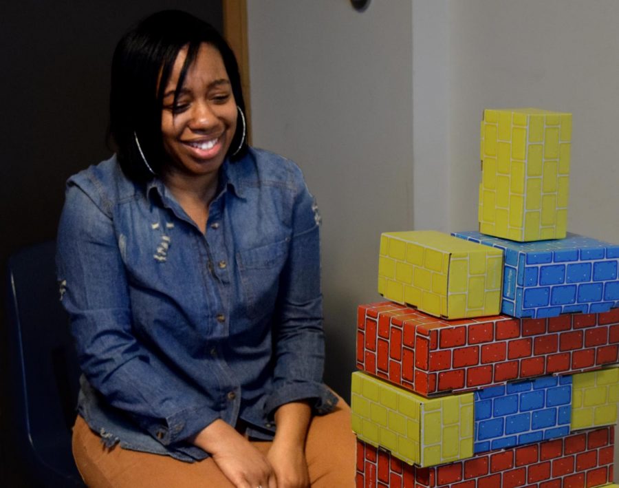LeLonna Goodson, a communication studies graduate student, is pictured at Tunnel of Opression Tuesday night in Thomas Hall. She built a tower with the “restrictions” given to her on a card, to showcase the importance of noticing a person’s strength versus their disability.