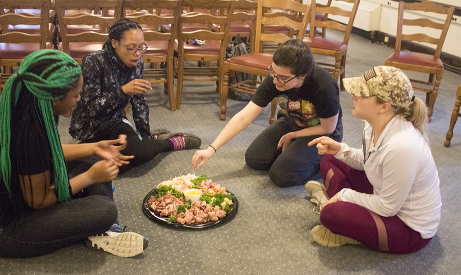 Students eat food on the floor during the Hunger Banquet, where they were placed in a group to demonstrate how the bottom 60 percent of the world might eat.