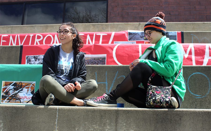 Olivia Swenson-Hultz | The Daily Eastern News
Stephanie Esparza, a sophomore kinesiology major and Nellie Schalasky, a senior management major sit on the Dounda steps that have been decorated for “I am Climate Change.”