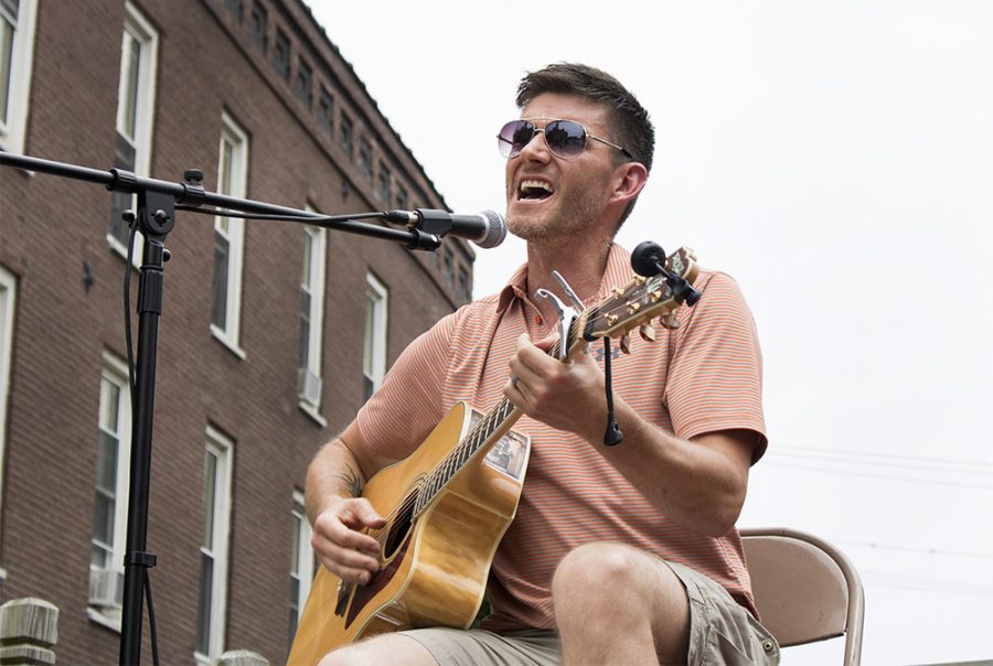 Jake Edwards, performs live music for the crowd at Muse Fest, Saturday evening in the Charleston Square. Edwards told the crowd he was filling in for his sister, who could not make it to the performance.