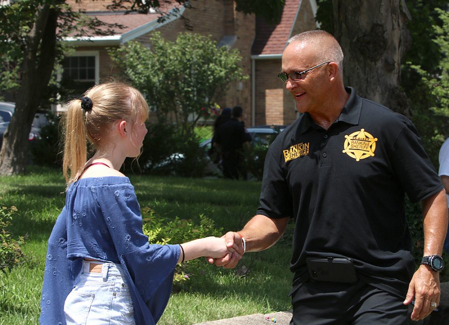 Coles County Sheriff Jimmy Rankin, shakes hands with Hannah Choat, an eighth grader at Charleston Middle School, Wednesday afternoon at the Fourth of July Parade.