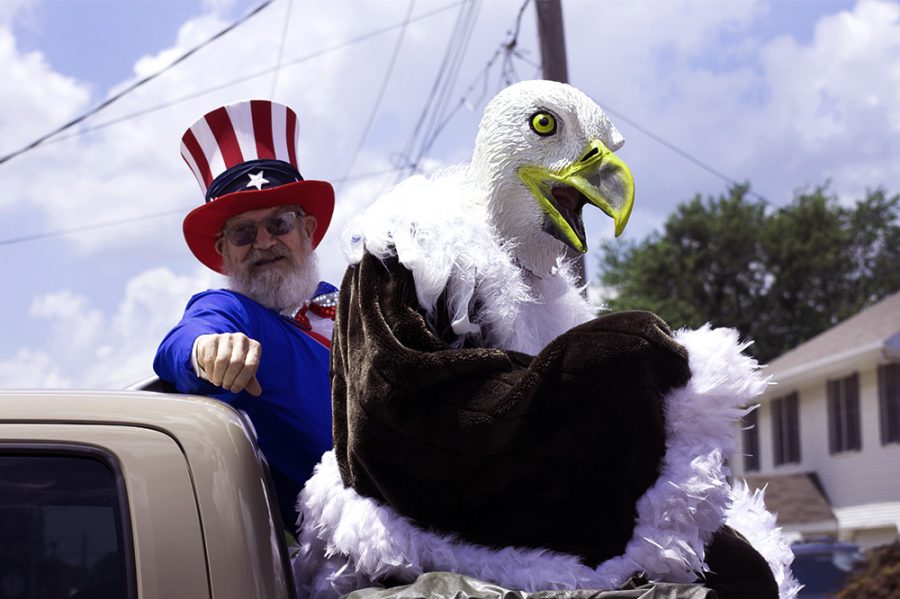 People dressed up as Uncle Sam and the American bald eagle wave to people, Wednesday afternoon at the Fourth of July Parade.