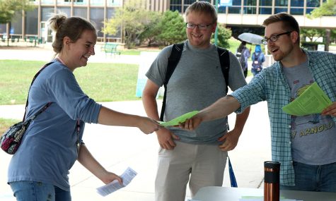 Jackson Frosch (right), a senior jazz performance major, and Aaron Jones (center), a junior music education major, talk to a student while handing out fliers for the Eastern Department of Music Ensembles Monday afternoon outside of the Doudna Fine Arts Center. The front page of the flier had commonly asked questions about the ensemble programs on campus. Such as “Do I have to audition?” and “Can I just try it for rehearsal to see if I like it before I sign up?” The back page had a list of faculty members to contact about the programs, along with a list of the ensembles the music department offers.