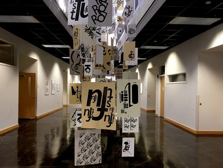 Student-created art hangs in the Doudna Fine Arts Center. This piece was created by a senior graphic design class and the advanced printmaking class under the supervision of Alan Pocaro, a professor of art, and Samantha Osborne, a professor of graphic design.