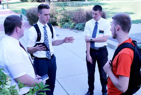 Elder Whitaker, Elder Tuckett and Elder Johnson, all missionaries for the Church of the Latter Day Saints, speak to David Younglove, a sophomore kinesiology major, Thursday afternoon outside of Klehm Hall. Missionaries devote two years of their lives to speak to people about their church. Tuckett said, “we wouldn’t leave our friends and families for two years to preach nonsense.”