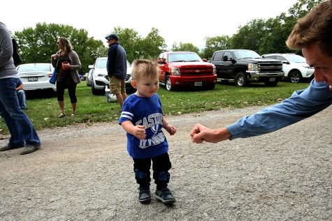Sam Morgan (right), a junior therapeutic recreation major, fist bumps Dawson Jackson (center), 22 months old, at the tailgate Saturday afternoon.