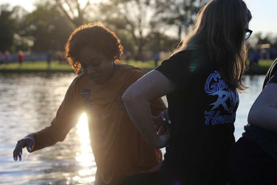 Tiana Webb (left), a senior business management major, returns to the shore of Campus Pond soaked after participating in the ROC Fest Boat Race Thursday evening.
