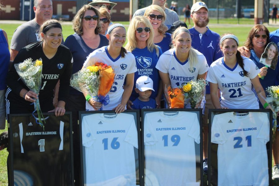 Senior members of the Eastern women’s soccer team pose with family members during a pregame ceremony for senior day on Sept. 30. Left to right; Maddie Lyon, Kayla Stolfa, Kate Olson and Elisabeth Held.