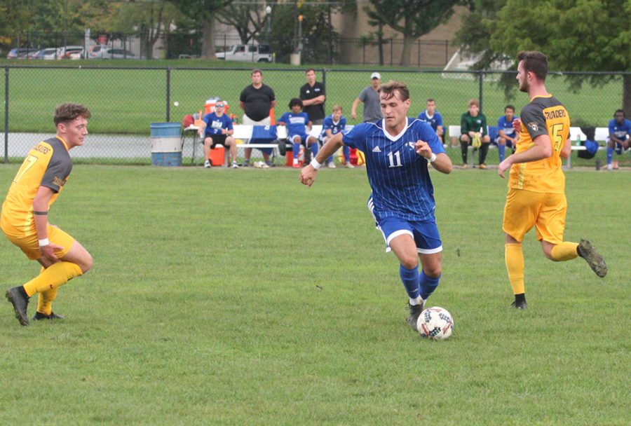 Toby Andrews dribbles the ball between a pair of Valparaiso defenders during the men’s soccer team’s 2-1 loss at Lakeside Field on Oct. 10.