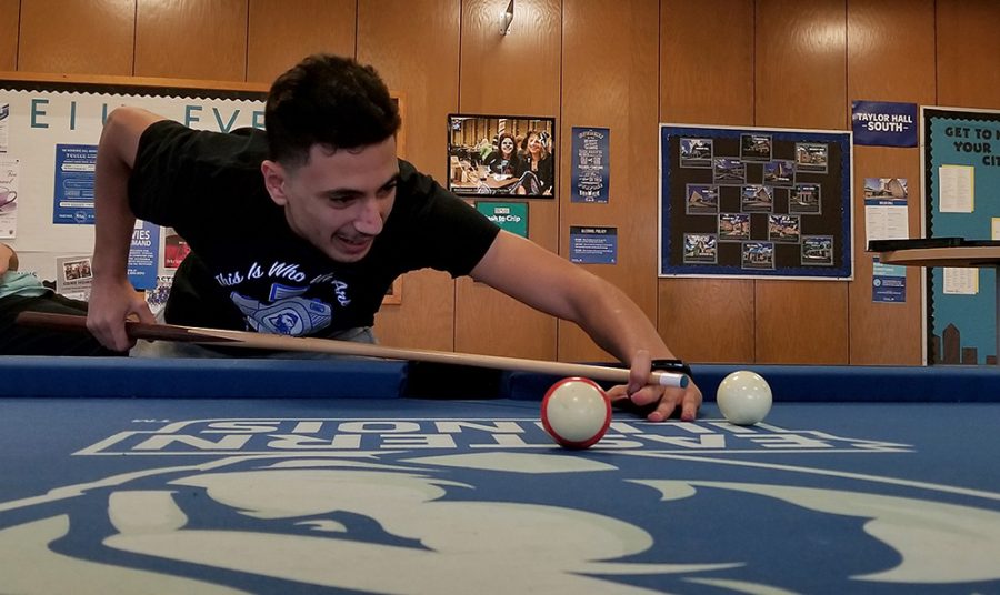 Saad Elkhelfi, a freshman marketing major, enjoys a close game of pool with his friends Tuesday afternoon in the Taylor Hall lobby.