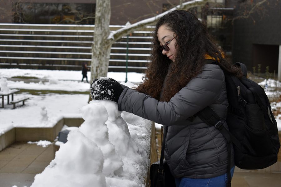 Jasmine Rivera, a freshman digital media major, makes a snowman for her photography class assignment in front of booth library on Wednesday afternoon.