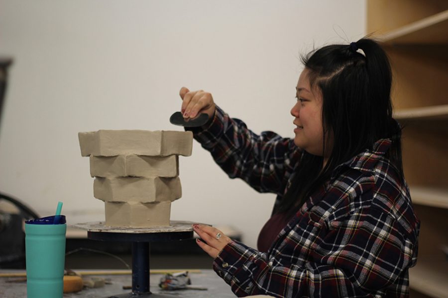 Kristina Wang, a senior early childhood development major, works on her ceramics project in the Doudna Fine Arts Center on Sunday evening.