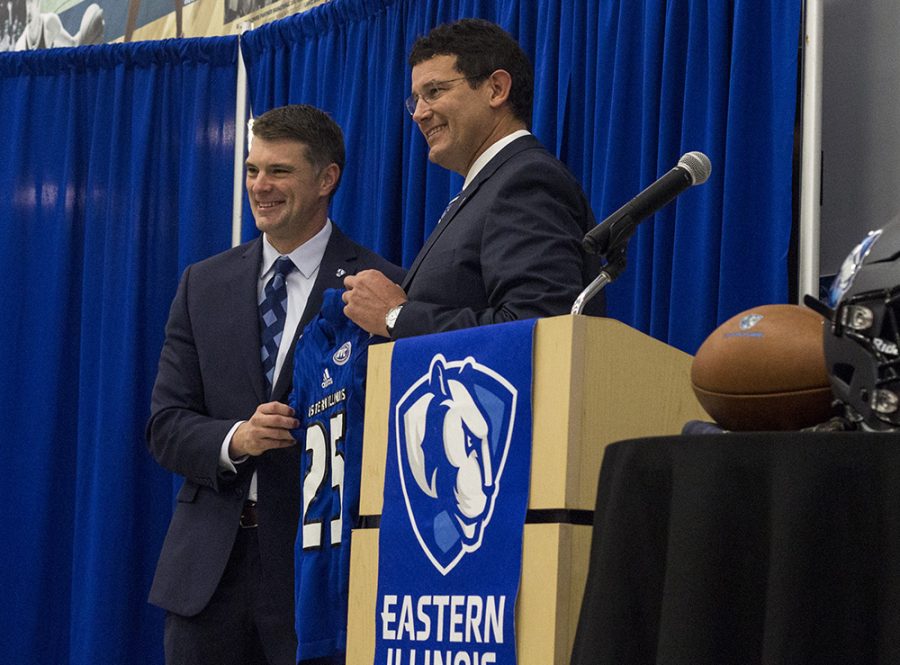 Analicia Haynes | The Daily Eastern News Adam Cushing (left) accepts an Eastern football jersey from Athletic Director Tom Michael during a press conference in December 2018. Cushing added Chris Bowers and John Kuceyeski to be his defensive and offensive coordinators.