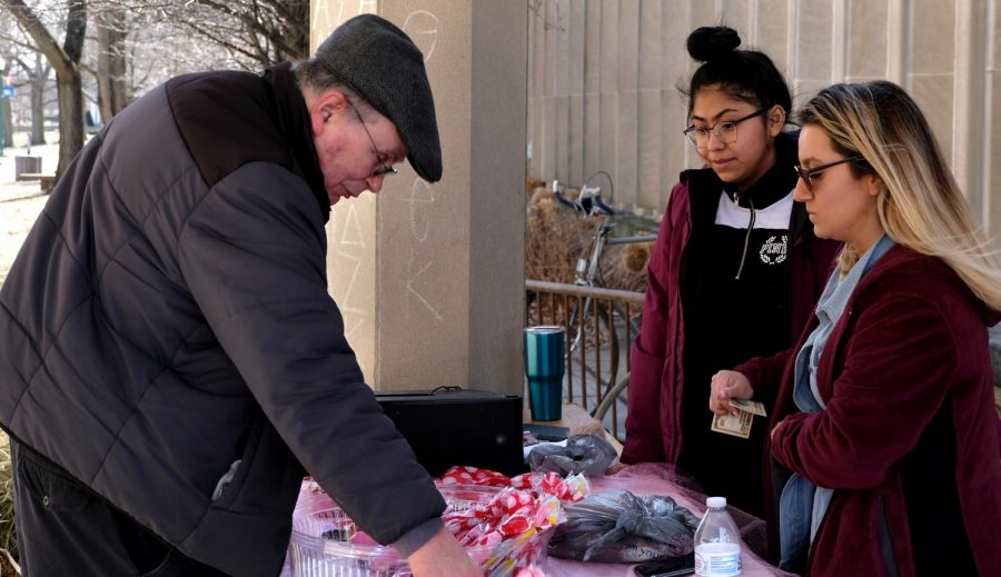 Esperanza members Yrely Robledo, an accounting major, and Gina Canchola a business management major, sell a man chocolate covered deserts Thursday afternoon outside of Coleman Hall.