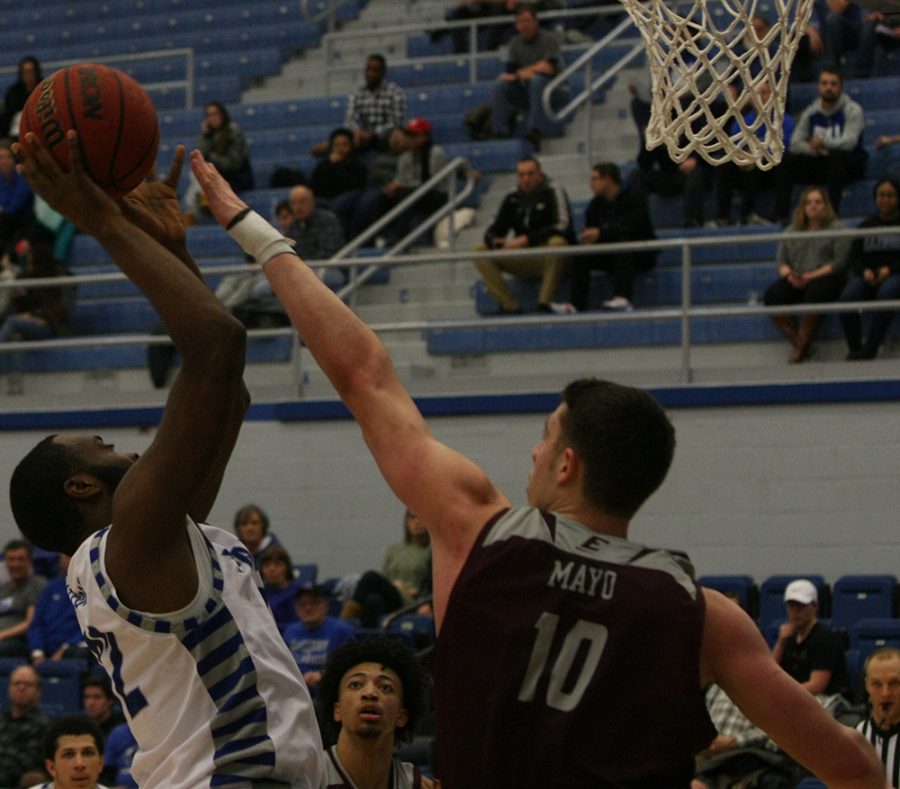 JaQualis Matlock attempts a shot attempt around the basket as Eastern Kentucky’s Nick Mayo tries to block it during Eastern’s 67-66 victory Jan. 31 in Lantz Arena.