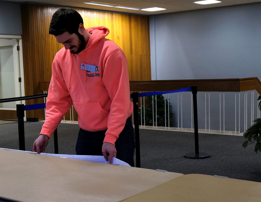 Student Worker Will Taylor, a junior human resources major, sets up a table for an upcoming event Wednesday afternoon outside of the Grand Ballroom in the Martin Luther King Jr. University Union.