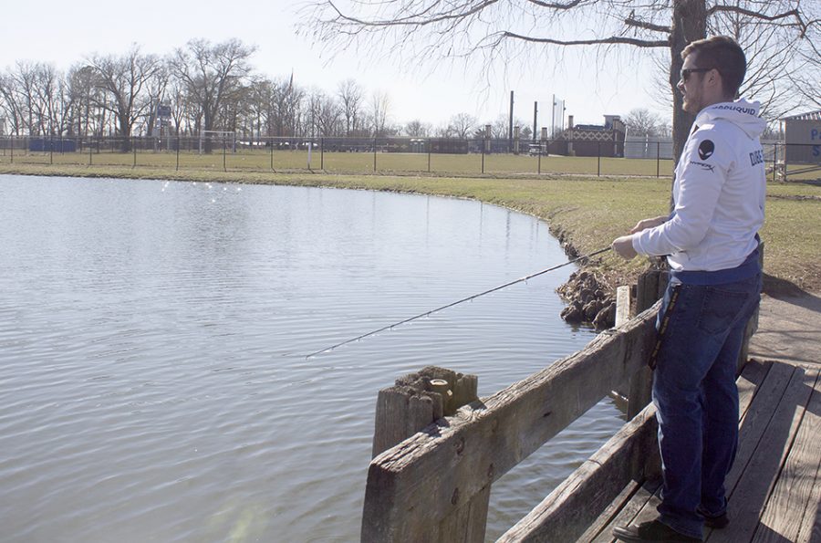 Theo Laleian, a junior computer information technologies major, fishing on the dock at the Campus Pond.