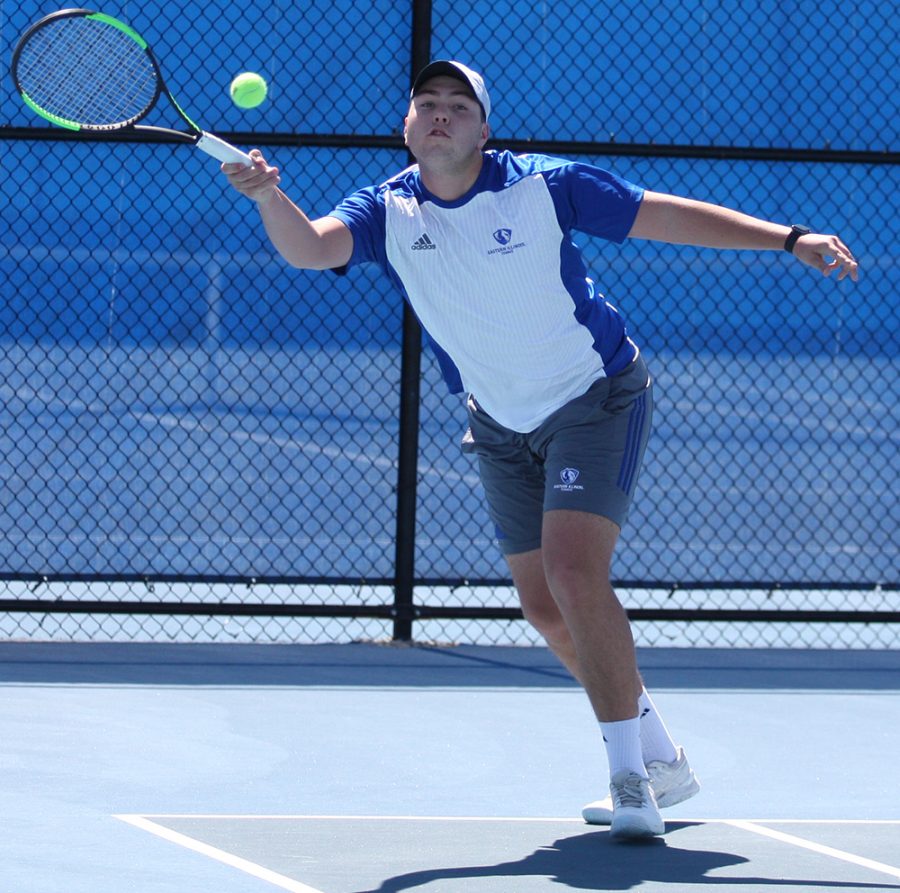 Gage Kingsmith lunges forward to return a hit during the Eastern men’s tennis team’s 7-0 loss to Belmont at the Darling Courts in March 2018.