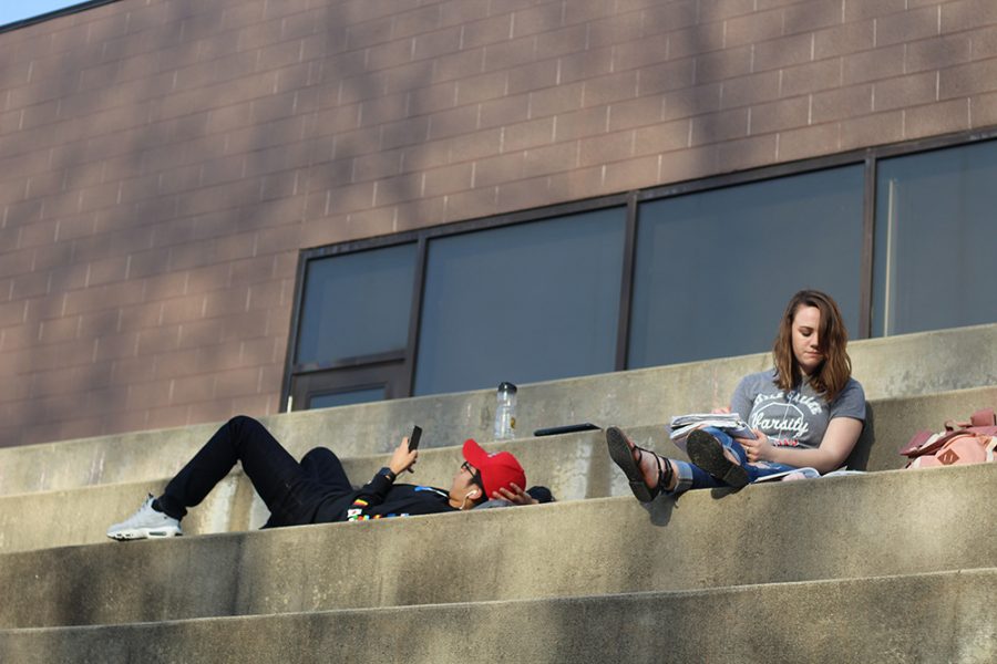 Vincent Rodriguez (left), a freshman engineering technology major, and Kat Stephens (right), an elementary education major, relax and enjoy the weather on the steps of the Doudna Fine Arts Center Sunday afternoon.