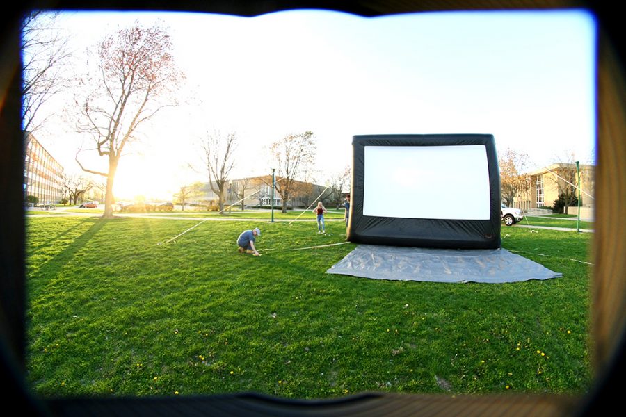 People set up the screen for the movie to be shown Wednesday afternoon in the South Quad. The University Board was showing the Disney movie “Inside Out.”