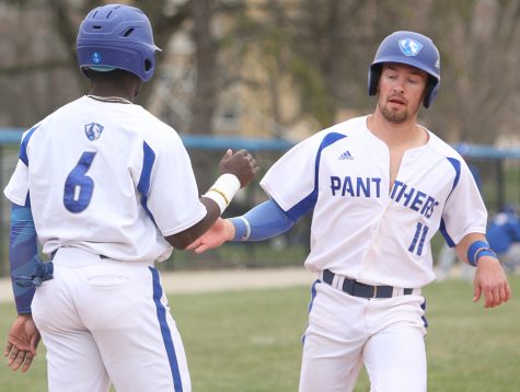 Eastern’s Jimmy Govern (11) and Wyell Woods (6) high five after Govern scored a run in the Panthers’ 11-1 win over Illinois College on April 3. Eastern has three road games against Morehead State this weekend.
