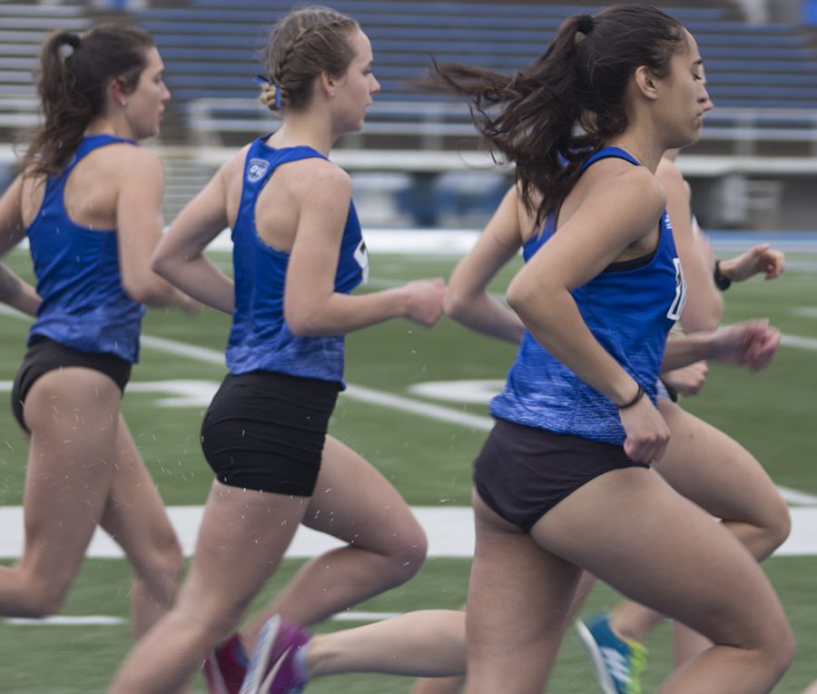 Abby Fisher (left) and Jocelyne Mendoza (right) run next to each other in a race during the EIU Big Blue Classic March 30 at O’Brien Field.