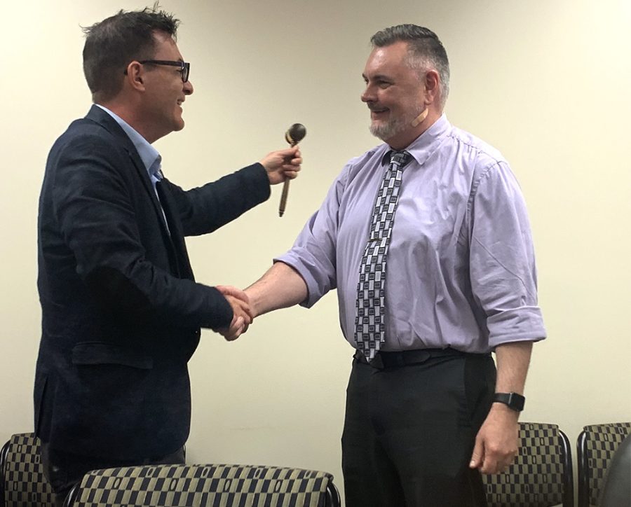 Faculty Senate member C.C. Wharram (left) accepts the gavel from Todd Bruns, the 2019 Faculty Senate chair, on May 2 during the Senate meeting at Booth Library. Wharram will be the next chair for the Senate starting in the fall. 