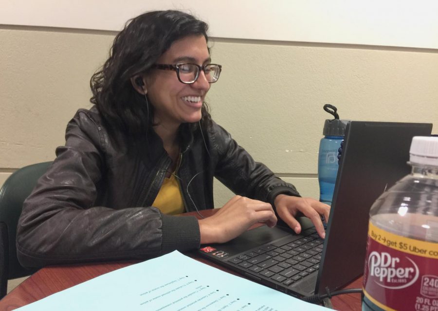 Humaira Ahmed, a counseling graduate student, works at her laptop for one of two classes she is taking over the summer at the Buzzard Hall Atrium. 
